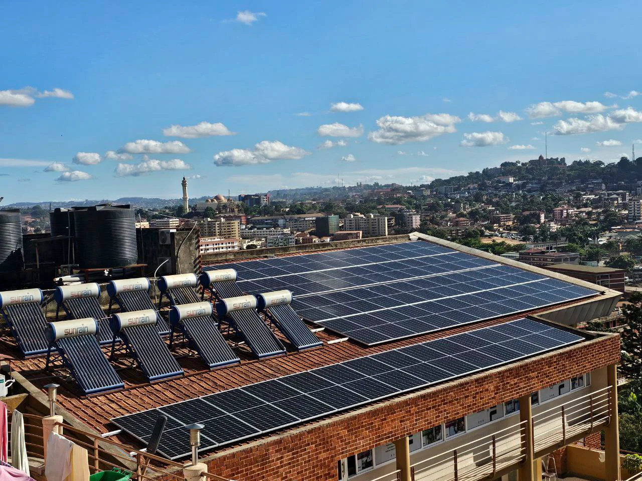 Rooftop solar panels and solar water heaters installed above an East African city