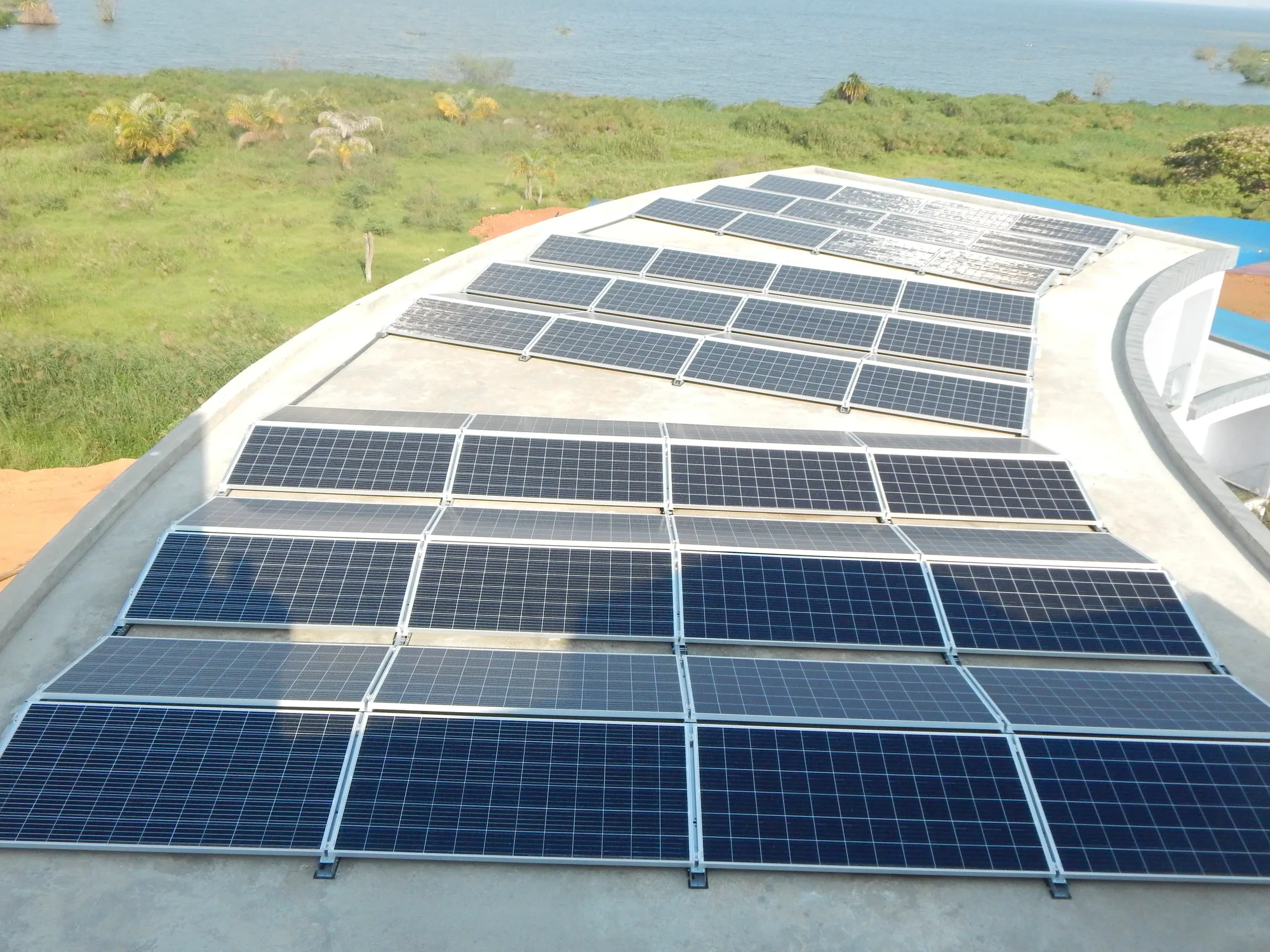 Curved solar rooftop array above a lake shoreline
